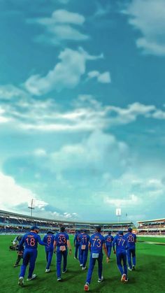 a group of men standing on top of a lush green field next to a stadium