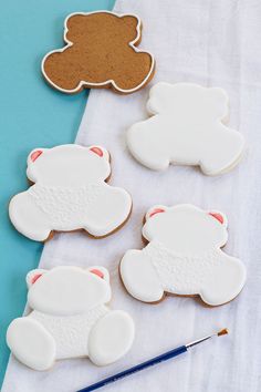 some cookies are laying on a table next to a paintbrush