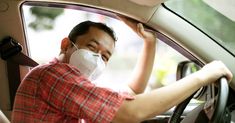 a man wearing a face mask while sitting in a car