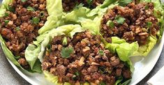 lettuce wraps filled with meat and garnished with cilantro leaves