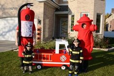 two children dressed up as firemen standing in front of a house with a fake fire hydrant