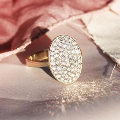 a diamond ring sitting on top of a pink cloth