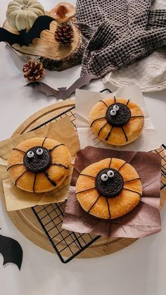 three donuts decorated to look like jack - o'- lanterns on a table