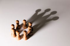 a group of wooden chess pieces sitting on top of a white table next to each other