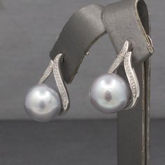 These elegant earrings feature luxe pearls with just a hint of sparkle. The earrings feature South Sea pearls measuring 11.26 and 11.08mm. The pearls are a blue silver color with lovely luster and glow. They are perched at the base of a teardrop design in white gold which is encrusted on the sides with round prong set diamonds. There are 20 of the small diamonds on each earring, measuring about 0.6mm, totaling about 0.10cttw. The stones are H/I color and I1/2 clarity with no eye visible inclusio Pearl And Diamond Earrings, Sea Pearl, South Seas, South Sea Pearls, Sea Pearls, Elegant Earrings, Blue And Silver, Prong Setting, Silver Color