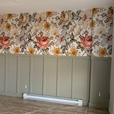 an empty room with green cabinets and floral wallpaper