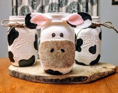 three mason jars decorated to look like cows