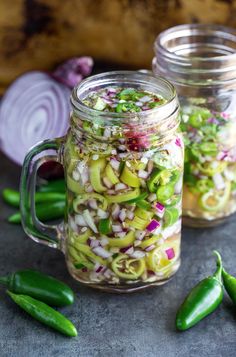 two mason jars filled with pickled onions and green peppers