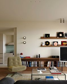 a living room filled with furniture and a flat screen tv on top of a wooden shelf