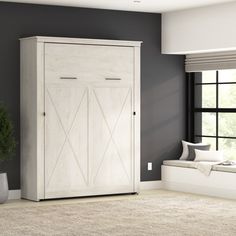 a living room with gray walls and a white cabinet next to a window in the corner