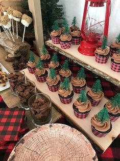 there are many cupcakes on the table with trees in them and other decorations