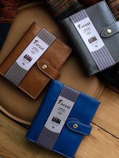 three wallets sitting on top of a wooden table