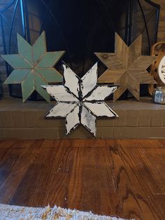 three wooden snowflakes sitting on top of a fireplace