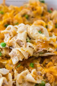 a casserole dish with chicken, peas and cheese on top in a white bowl