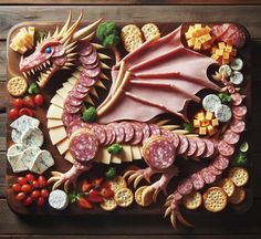 a dragon made out of cheese, meats and crackers on a cutting board