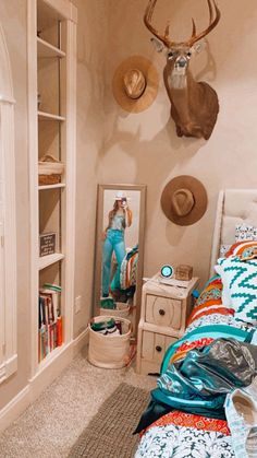 a bed room with a neatly made bed and a deer head mounted on the wall