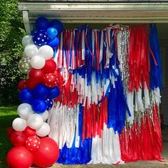 red, white and blue streamers are hanging from the side of a house