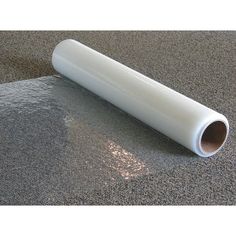 a roll of white vinyl sitting on top of a carpeted floor next to a wall