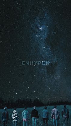 people standing in a field looking up at the night sky with the word enhypen written on it