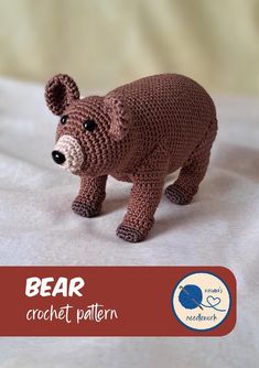 a crocheted bear is standing on a bed with the words bear written below it