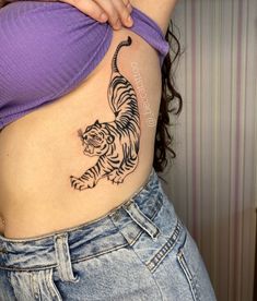 a woman's stomach with a tiger tattoo on her belly and the bottom part of her stomach