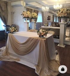 a table covered with a white cloth and flowers