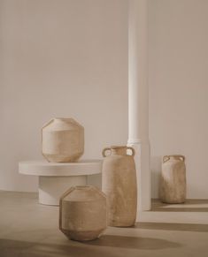 three vases sitting on top of a white table