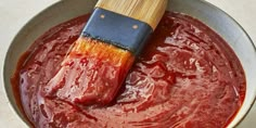 a wooden spatula in a pan filled with red sauce