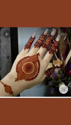 a woman's hand with henna tattoos on it