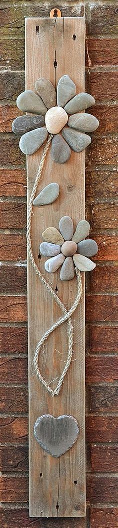 a wooden plaque with metal dragonflies on it's sides and rope hanging from the side