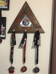 several medals are hanging on the wall in front of a clock and other items that have been pinned to it