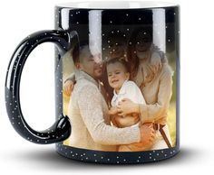 a black coffee mug with an image of two men and a woman holding a baby