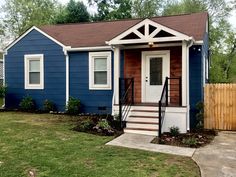 a blue house with white trim on the front door and steps leading up to it