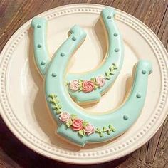 two decorated cookies sitting on top of a white plate