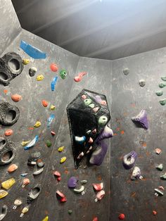 an indoor climbing wall with various colored rocks