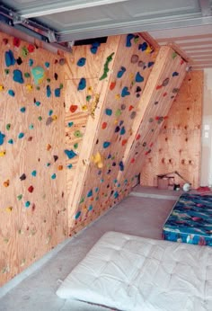 a room with climbing walls and mattresses in it