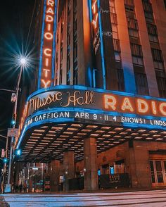 the radio city music hall sign is lit up at night