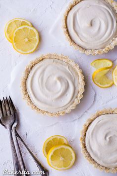 three lemon pies on a white surface with forks