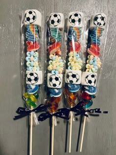 four lollipops with soccer balls on them