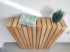 a book is sitting on top of a wooden table next to a potted plant