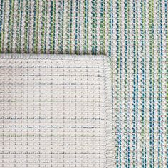 close up view of an area rug with blue, green and white stripes