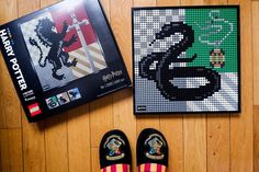 a pair of shoes sitting on top of a wooden floor next to a lego poster