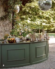 an outdoor bar with lots of vases and flowers on it