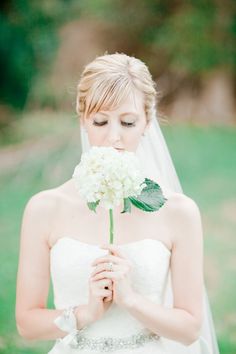 a woman in a wedding dress holding a flower