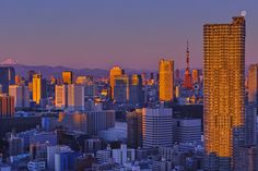 a city skyline with tall buildings and mountains in the background