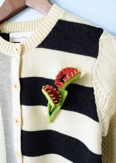 a close up of a sweater with a flower on it