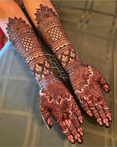 two hands with henna designs on them