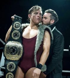 a man and woman in wrestling gear kissing