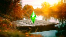 a green umbrella sitting on top of a wooden dock