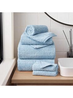 a stack of blue towels sitting on top of a wooden counter